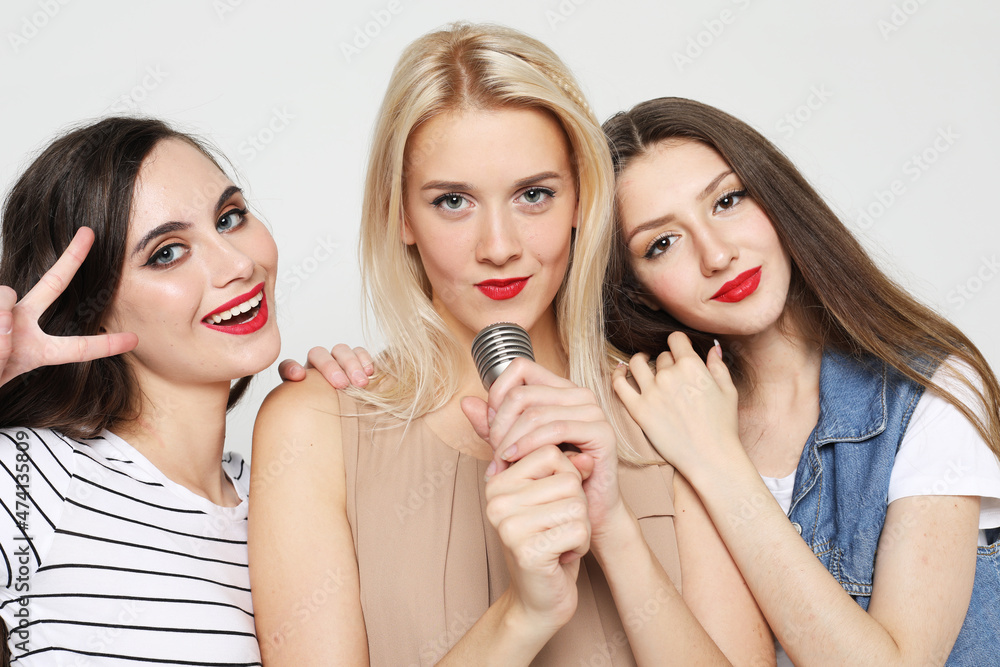 young hipster women with a microphone singing and having fun young hipster women with a microphone singing and having fun