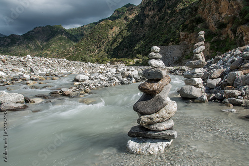 Sassi in equilibrio in primo piano sul letto del Torrente Amendolea in una giornata nuvolosa