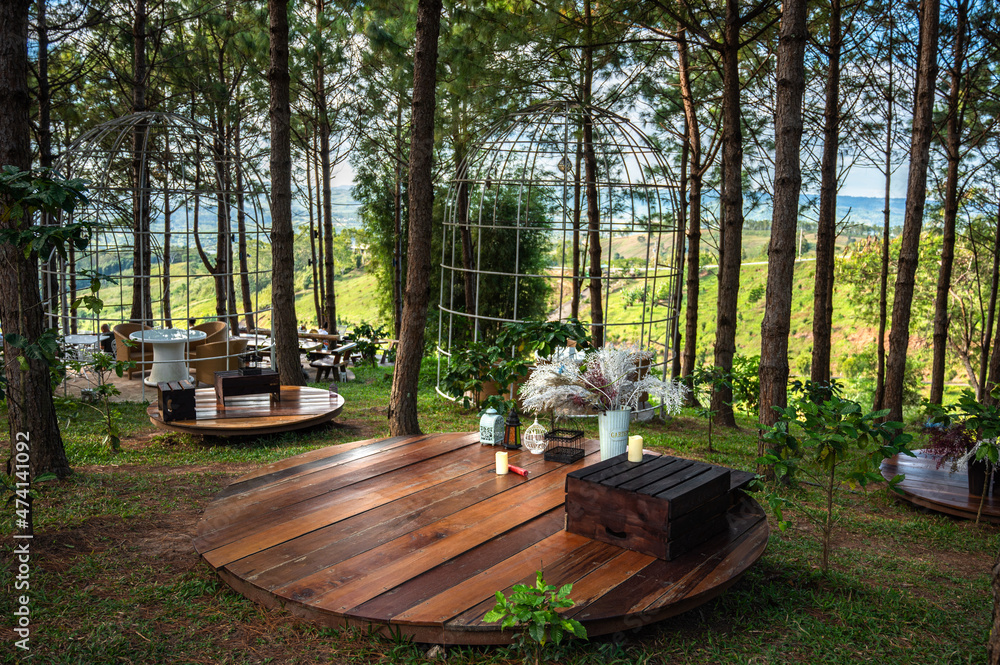Beautiful landscape at cafe style with wooden rest seat, tables and chairs terrace against the outdoor Mountain view.