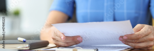 Businesswoman examines financial documents with business reports closeup