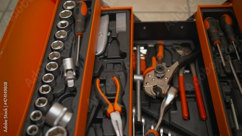 A hand picks pliers up from the toolbox.