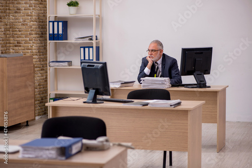 Aged businessman employee sitting in the office