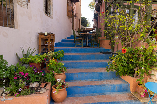 Fototapeta Naklejka Na Ścianę i Meble -  Small narrow street with blue stairs in Old Town of Rethymnon, Crete island, Greece