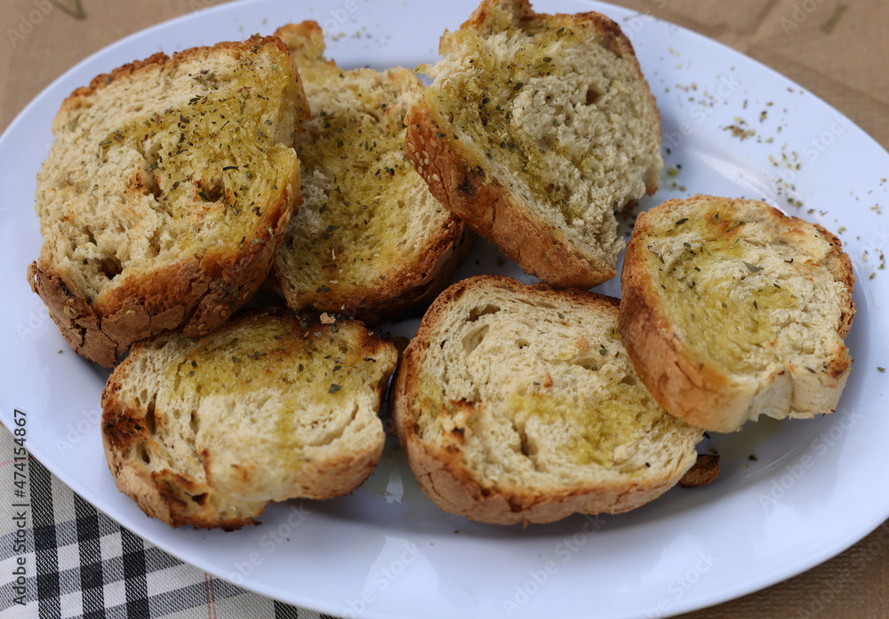 baguette slices with garlic and olive oil on a white plate baguette slices with garlic and olive oil on a white plate
