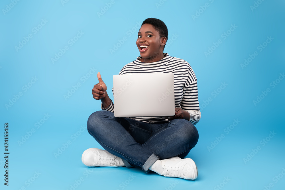 Oversized African American Lady Using Laptop Gesturing Thumbs-Up, Blue Background Oversized African American Lady Using Laptop Gesturing Thumbs-Up, Blue Background