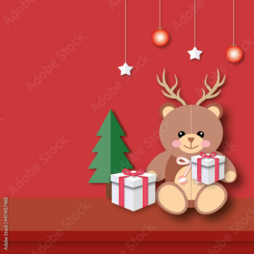 Teddy bear holding a gift wearing antlers with Christmas tree, ball and stars on red background. Merry Christmas and Happy New Year concept. space for the text. paper art design style.