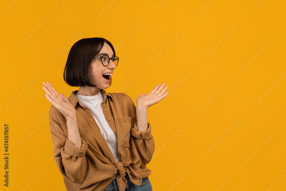 Huge sale or promo concept. Overjoyed caucasian woman screaming and looking at free space on yellow background Huge sale or promo concept. Overjoyed caucasian woman screaming and looking at free space on yellow background