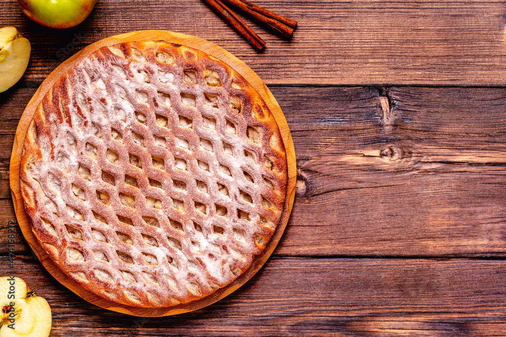 Homemade apple pie with cinnamon on a wooden background. Homemade apple pie with cinnamon on a wooden background.
