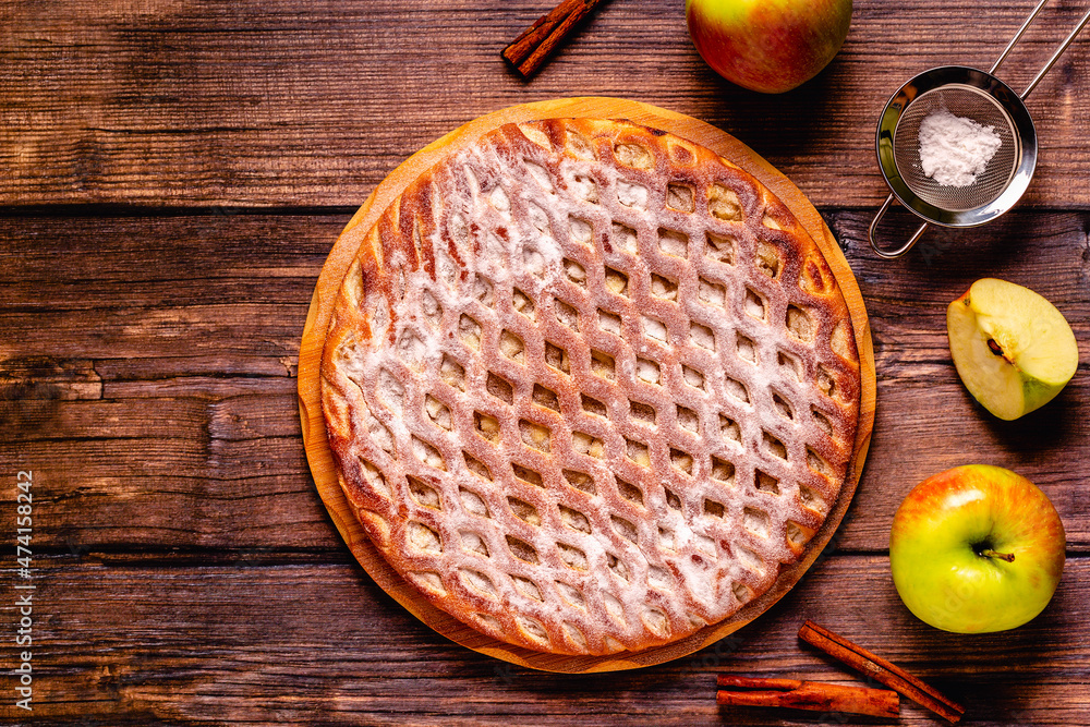Homemade apple pie with cinnamon on a wooden background. Homemade apple pie with cinnamon on a wooden background.