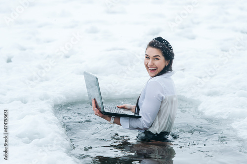 Obraz na plátne Girl with laptop in frozen lake ice hole