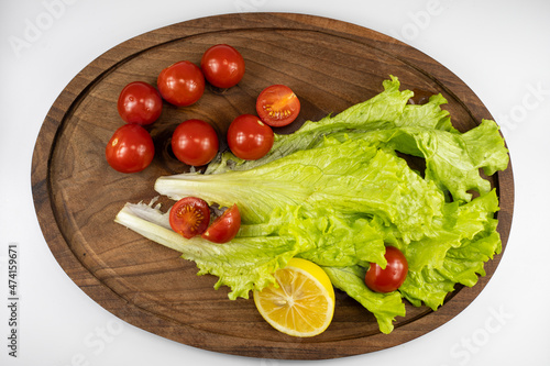 Red tomatoes lemon and lettuce on the table. Vegetarian healthy food