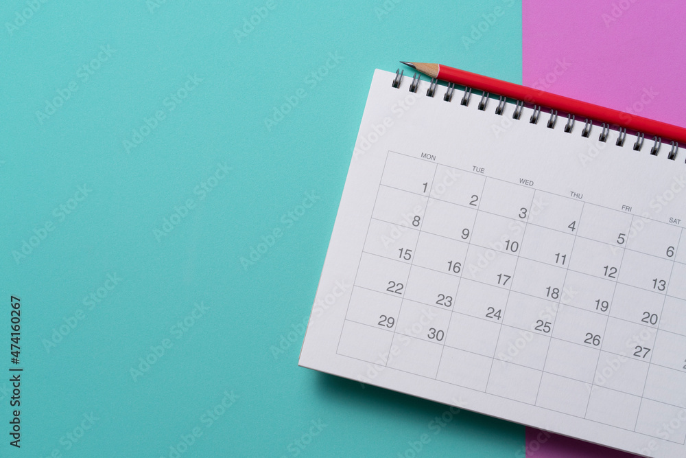 close up of calendar and pencil on the green and pink table background, planning for business meeting or travel planning concept close up of calendar and pencil on the green and pink table background, planning for business meeting or travel planning concept