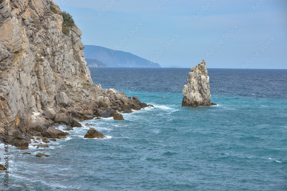 a piece of rock near the sea near the coast, a view of the coastal rocks near the castle Swallow's Nest in Crimea, a detached large piece of rock in the middle, coastline on the left, sea view