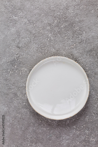 Empty white plate on gray concrete background