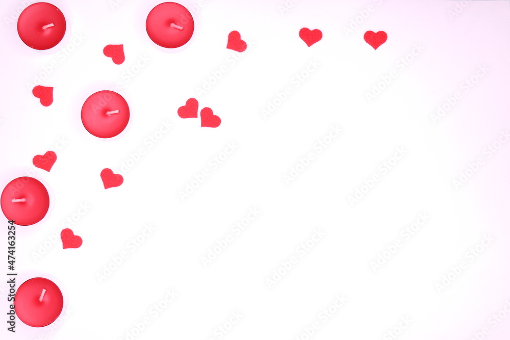 Top view on red candles and small hearts on white background 