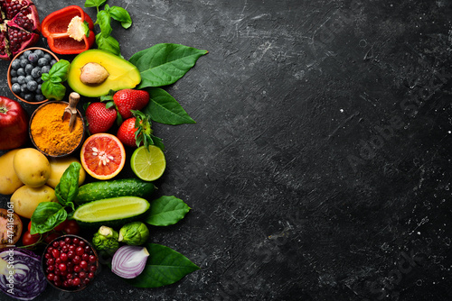 Food. Set of fresh vegetables and fruits on a black stone background. Organic food. Top view. Free space for your text. © Yaruniv-Studio