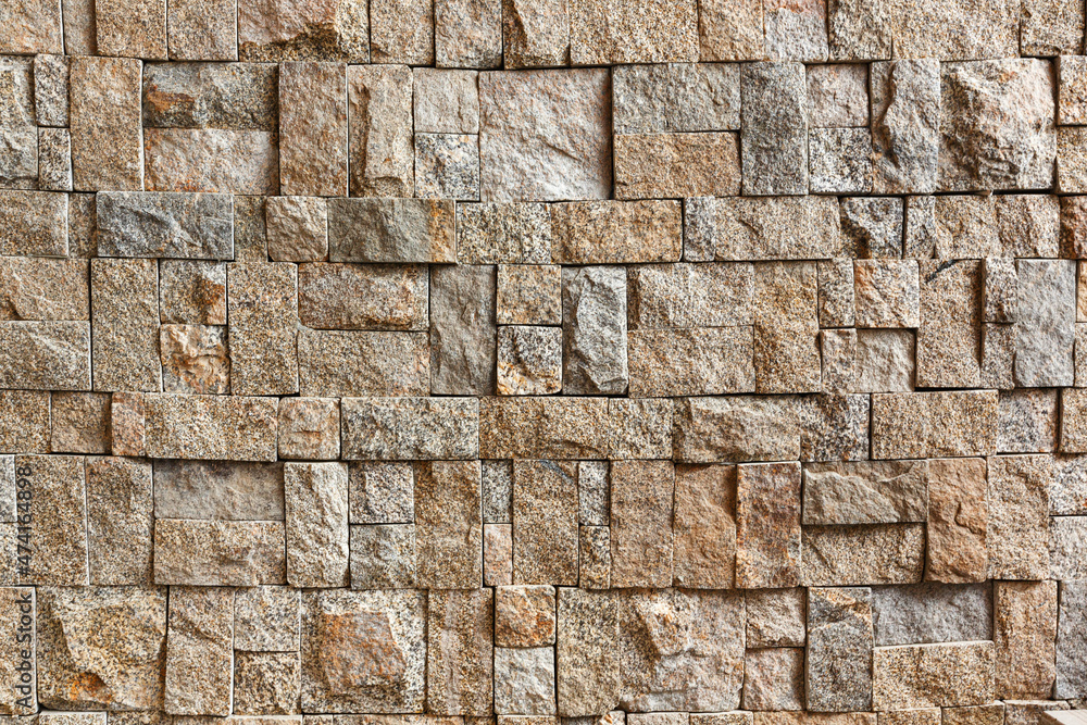 The rough texture of the surface of the wall faced with rectangular granite blocks of different sizes. The rough texture of the surface of the wall faced with rectangular granite blocks of different sizes.