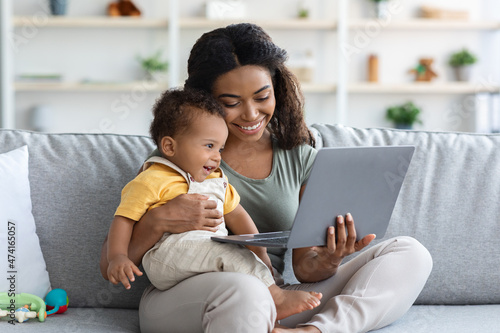 Happy African American Mother And Infant Baby Using Laptop At Home