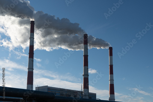 Photo of smoking pipes of a thermal power plant at the background of sky