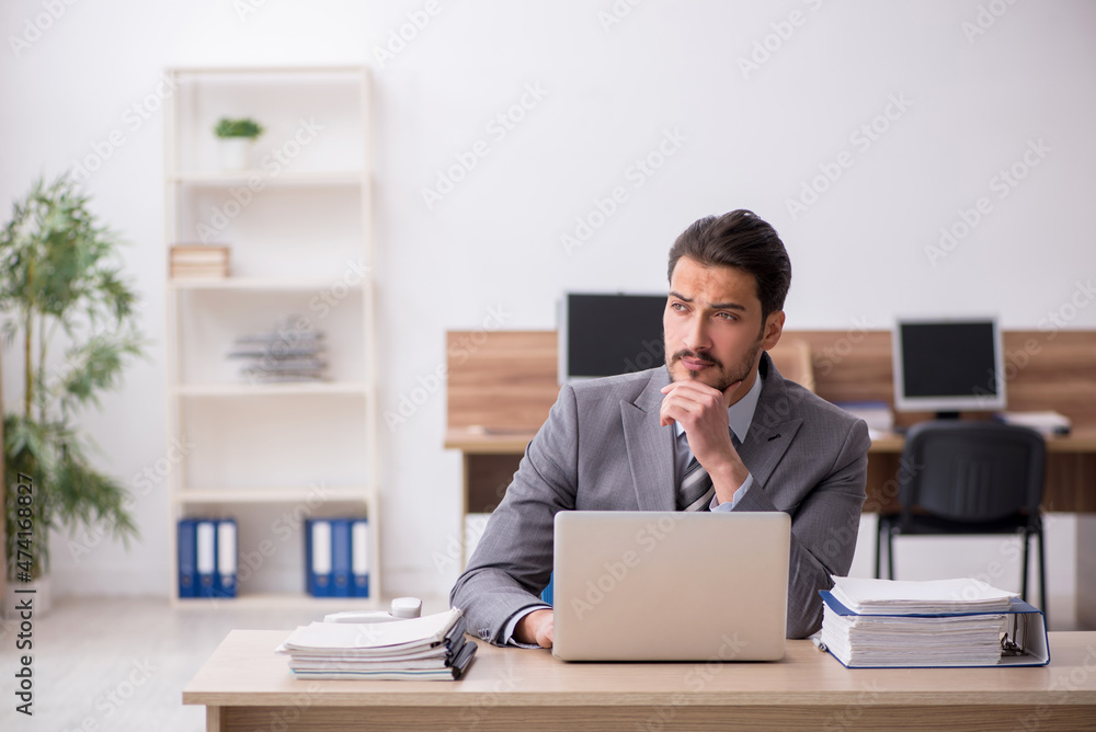Young male employee working in the office Young male employee working in the office
