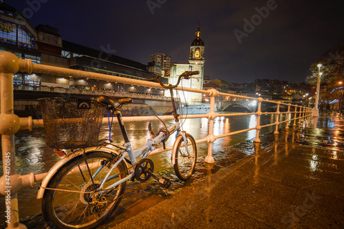 Bicycle next to the Bilbao estuary at dusk with rain