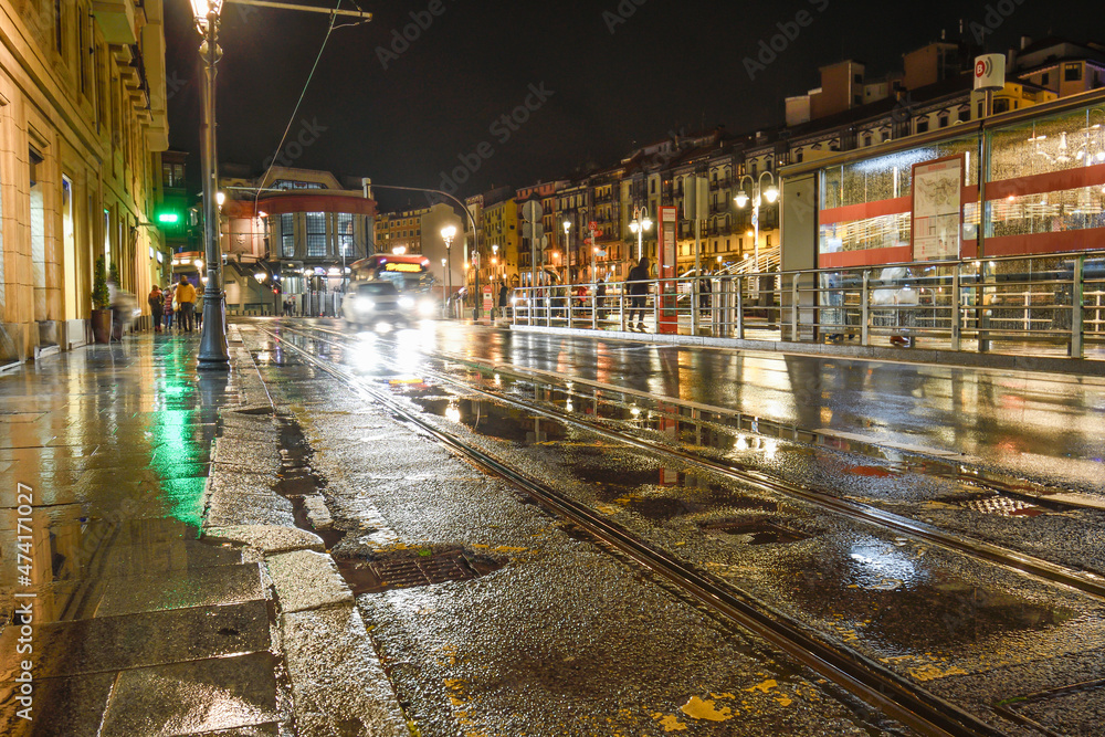 Bilbao tram tracks at night and wet next to the Mercado de la ribera