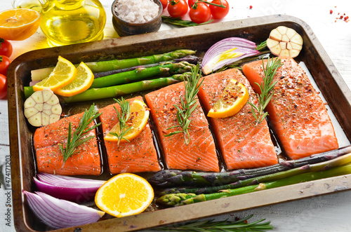 Cooking Salmon with rosemary, lemon and vegetables. Recipe. Seafood. Top view. Free space for text.