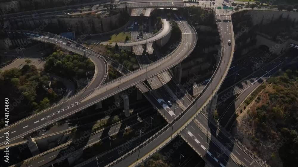 Aerial view of extensive road system, intersections and quiet city traffic situation with passing cars, at sunset in the evening Aerial view of extensive road system, intersections and quiet city traffic situation with passing cars, at sunset in the evening