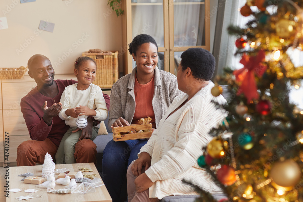 Portrait of big happy African-American family decorating home for Christmas together while enjoying holiday season in cozy atmosphere