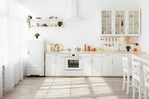 Kitchen with light walls, white furniture and small refrigerator in dining room scandinavian design © Prostock-studio