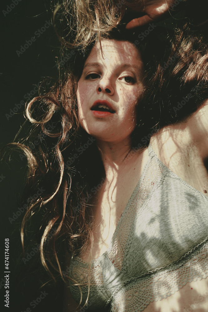Body positive portrait of a young woman with light and shadows