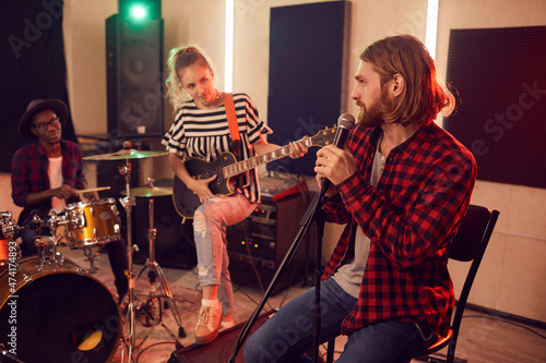 Fotografie Wide angle portrait of contemporary band playing music during rehearsal or conce