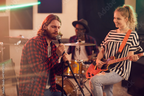 Foto Portrait of bearded man singing to microphone during rehearsal or concert with m