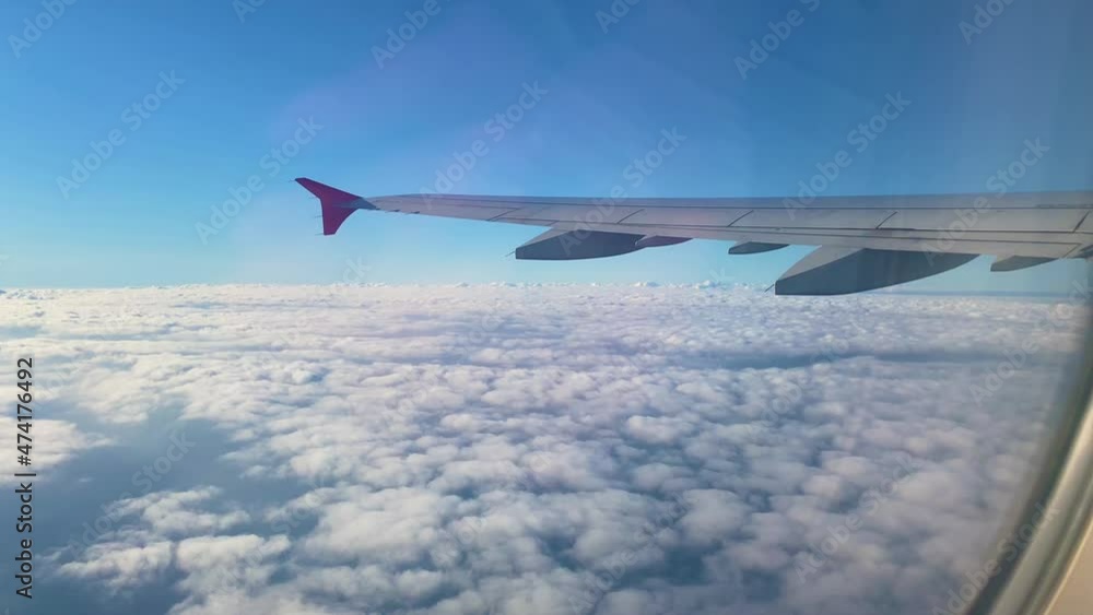 View from the window of the plane. Aircraft. Beautiful cloud and wing of airplane from window with a nice blue sky. View from the window of the plane. Aircraft. Beautiful cloud and wing of airplane from window with a nice blue sky.