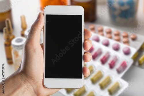 Patient hand using smartphone. Pharmaceutical use. Drugs. Pills. Prospectus. Using Smarthphone