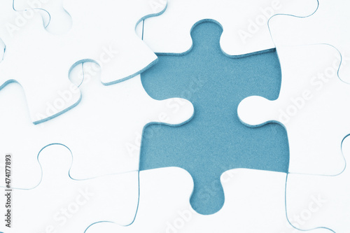 White jigsaw puzzles background, one piece missing and ready to connecting. Business strategy, teamwork, problem solving and complete mission concept. 