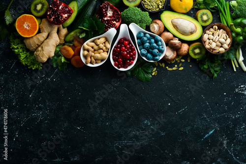 Healthy food. Vegetables and fruits. On a black wooden background. Top view. Copy space. © Yaruniv-Studio
