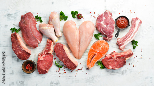 Banner. Raw meat steaks salmon, beef and chicken on a white wooden background. Organic food. Top view. photo