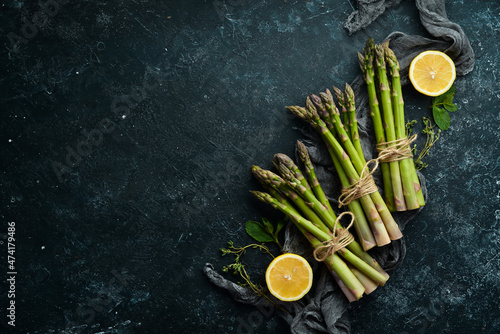 Fresh green asparagus on a black stone background. Healthy food. Top view, free copy space.