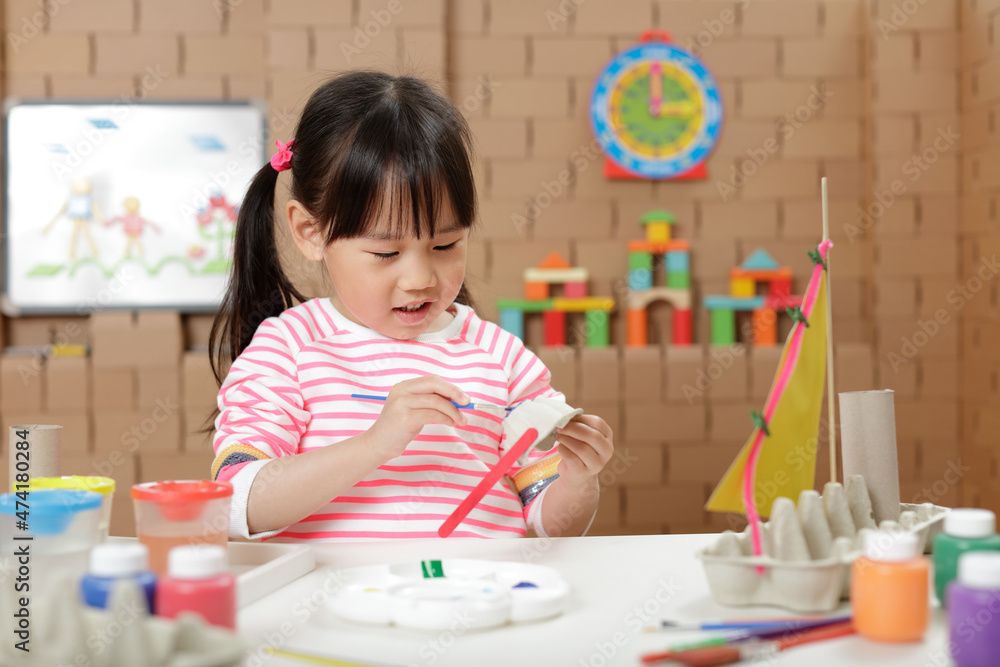 young girl painting egg carton glasses craft at home young girl painting egg carton glasses craft at home