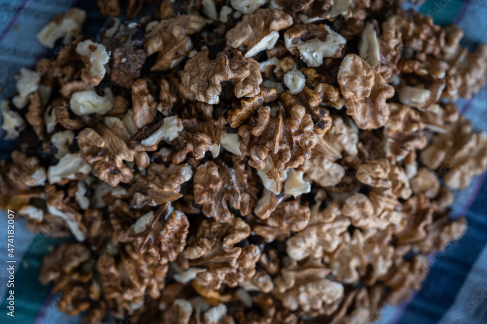 Woman cracking walnuts with hammer, Cracked brown walnut shells and stone, cracked walnut shell texture Woman cracking walnuts with hammer, Cracked brown walnut shells and stone, cracked walnut shell texture