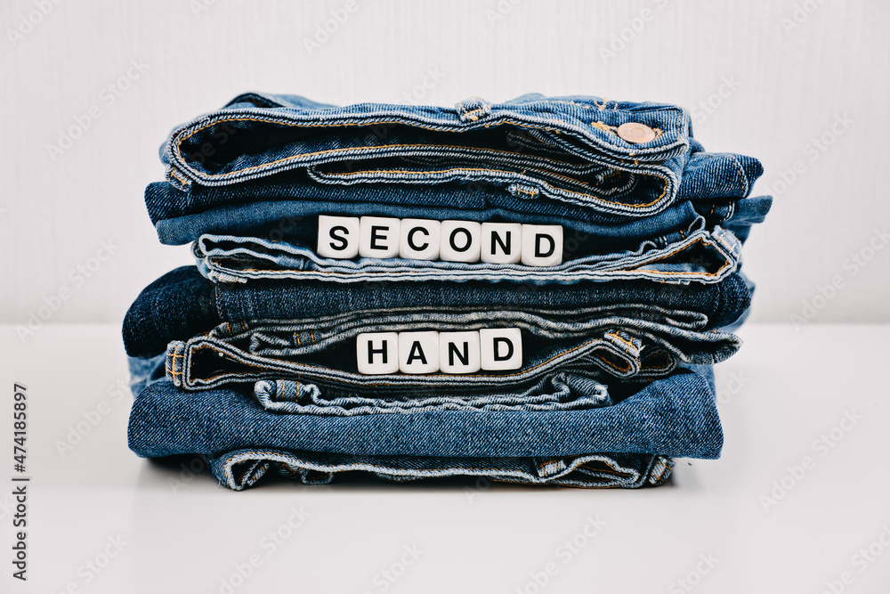 Second hand, Vintage Shopping, slow fashion, Sustainable fashion concept.  Stack of blue old denim jeans with the words second hand Stock Photo |  Adobe Stock