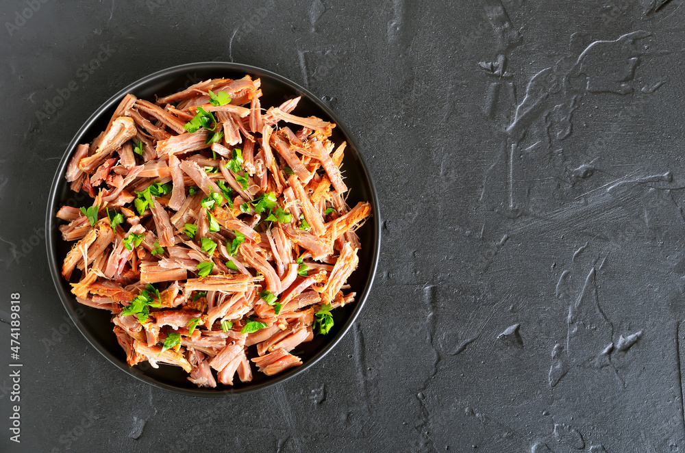 Slow cooked pulled beef for sandwiches with parsley on plate Slow cooked pulled beef for sandwiches with parsley on plate