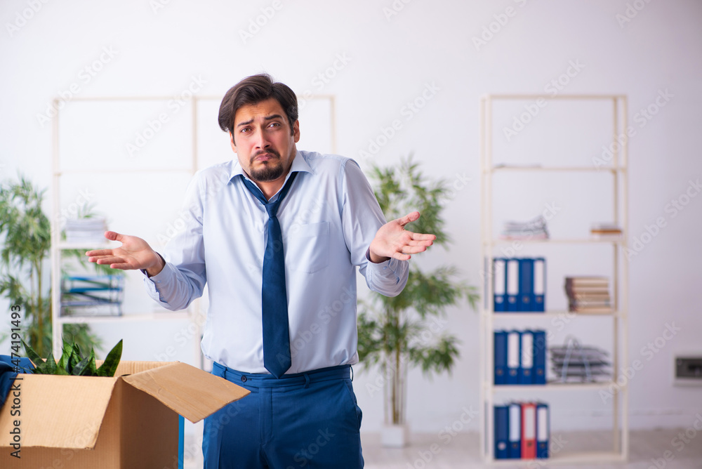 Young male employee in business relocation concept Young male employee in business relocation concept