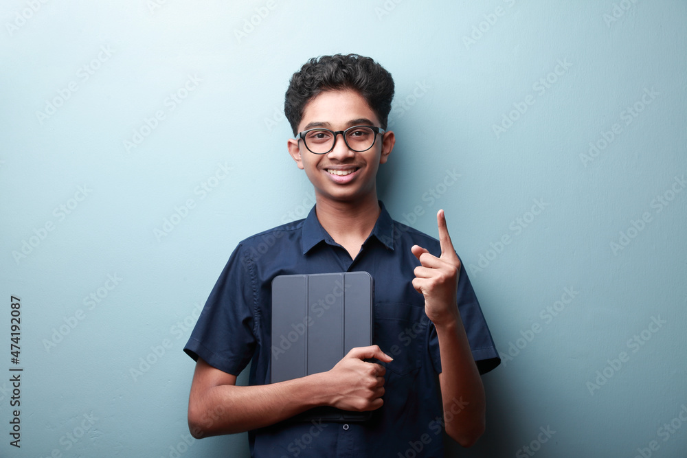 Happy boy of Indian ethnicity shows hand gesture pointed up Happy boy of Indian ethnicity shows hand gesture pointed up