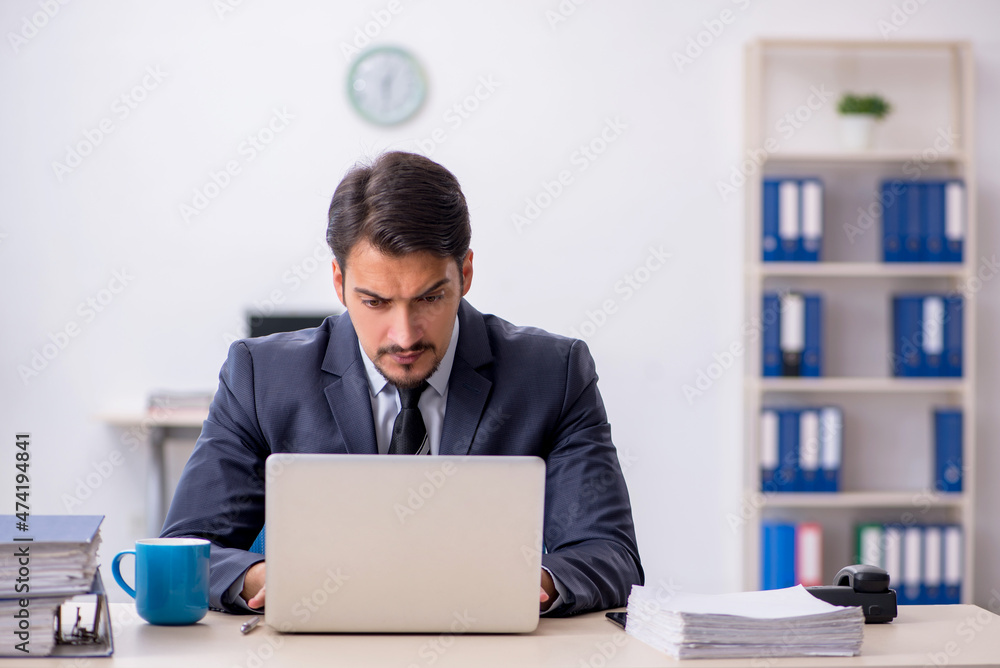Young male employee sitting at workplace Young male employee sitting at workplace