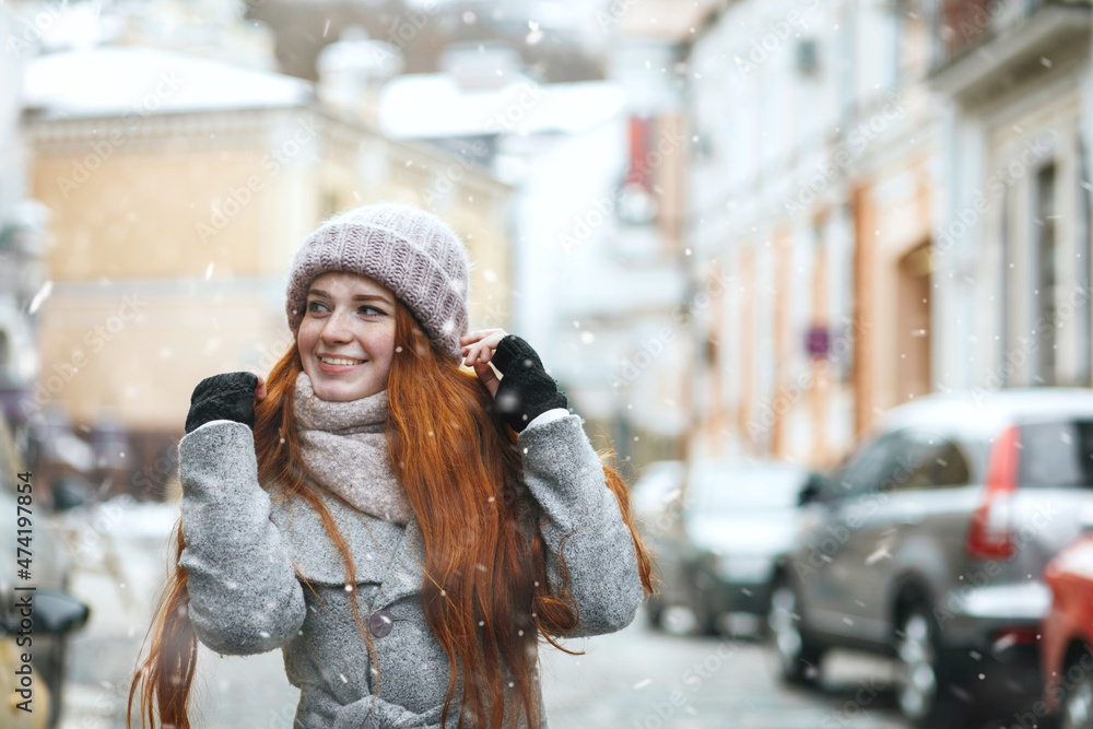 Obraz premium Glorious redhead lady walking at the city during new year vacation