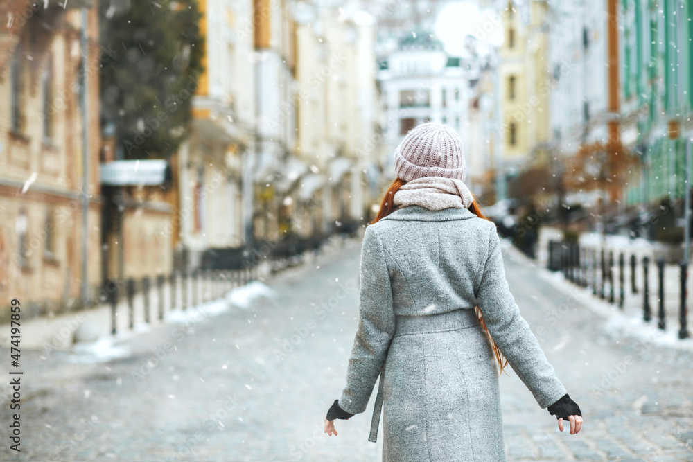 Pretty red head woman walking at the street during winter vacation