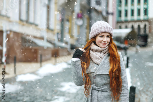 Elegant redhead lady walking at the city during new year vacation