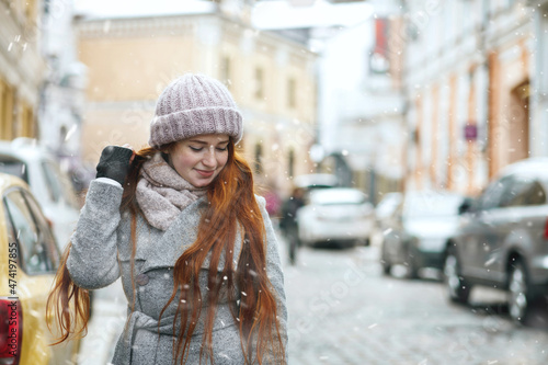 Alluring redhead lady walking at the city during new year vacation